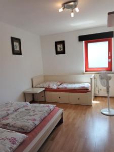 1 dormitorio con 2 camas, ventana y ventilador en Ferienwohnung J8, Playmobil Funpark Zirndorf Nürnberg, en Zirndorf