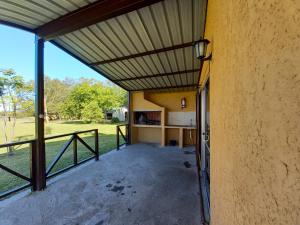 un porche de una casa con toldo y valla en Posada del Pio, Posada de campo, en Termas del Daymán