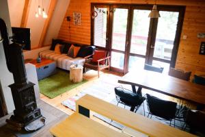 a living room with a couch and a table and chairs at Cabin & Apartment Kopaonik in Kopaonik