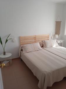 een slaapkamer met een groot bed met 2 kussens bij Apartamento Tres Pinos cerca de la Playa in San José