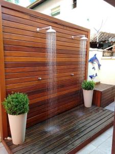 eine Dusche mit zwei Pflanzen vor einem Holzzaun in der Unterkunft Casa Temporada Prainha de Mambucaba Paraty RJ in Paraty