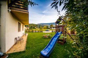 卡爾帕奇的住宿－Pogodne Siedlisko Karpacz，庭院里一个带蓝色滑梯的游乐场