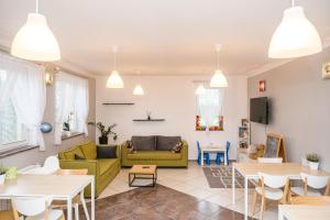 a living room with a yellow couch and tables at Pogodne Siedlisko Karpacz in Karpacz