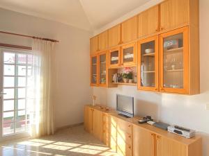 AbadesにあるChalet con terraza soleadaのキッチン(木製キャビネット付)、カウンター内のテレビ付