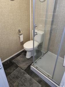 a bathroom with a toilet and a glass shower stall at Chalet 81 South Shore Bridlington 2x Bedroom Detached Chalet Sleeps 4 in Bessingby +24 photos