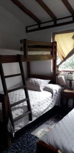 Cabaña El Mirador M&G في La Capilla: غرفة نوم بسريرين بطابقين وسلم