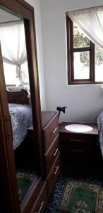 a bedroom with a mirror and a sink and a bed at Cabaña El Mirador M&G in La Capilla
