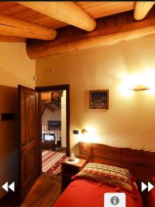 een slaapkamer met een bed en een houten plafond bij Les Chevreuils in Arvier