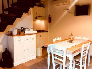 een keuken met een witte tafel en stoelen in een kamer bij Maison del Borgo in Colle di Val d'Elsa