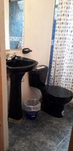 a bathroom with a black toilet and a sink at Cabaña El Mirador M&G in La Capilla