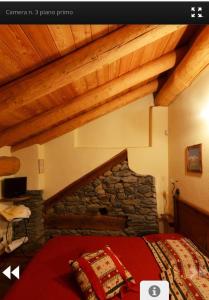 a bedroom with a bed and a stone fireplace at Les Chevreuils in Arvier