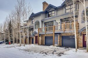 a house with two garage doors in the snow at Premiere 2Br Townhome - Shuttle to Slopes, Kids Ski Free! condo in Keystone