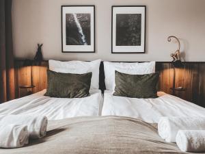 a bedroom with two beds and two pictures on the wall at Siljansnäs Hotell in Siljansnäs