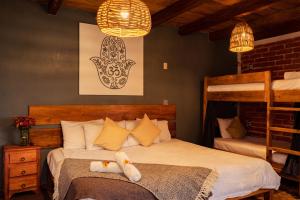 a bedroom with two beds and a bunk bed at Hospedaje Boutique Paz Creativa in San Cristóbal de Las Casas