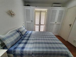 a bedroom with a bed with a blue plaid blanket at Apartamento Angra dos Reis 1 in Angra dos Reis