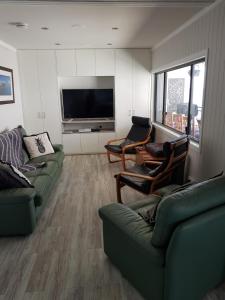 een woonkamer met banken en een flatscreen-tv bij Waterfront Location - 2 Bed Apartment in Corlette, Port Stephens - Sleeps 4 in Corlette