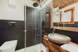 łazienka z umywalką i przeszkloną kabiną prysznicową w obiekcie Hotel Ciasa Lorenzi w mieście Cortina dʼAmpezzo +37 zdjęć