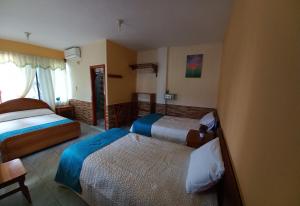 ein Hotelzimmer mit 2 Betten und einem Fenster in der Unterkunft HOSTAL JANET STARLiNK in Puerto Villamil