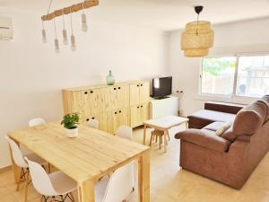 sala de estar con mesa de madera y sofá en Can Xiquets, en Riumar