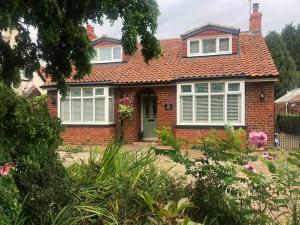 a red brick house with a green door at HAYFIELD COTTAGE spacious detached luxury home in Copmanthorpe