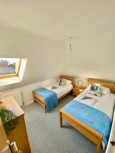 um quarto com duas camas e uma janela em Swanage Holiday Penthouse Apartment, Moments from Beach and Town, On Site Parking, Fast WIFI, Sleeps up to 6, Rated Exceptional em Swanage