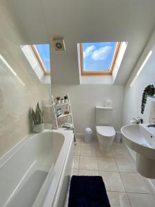 a bathroom with a tub and a toilet and a sink at Swanage Holiday Penthouse Apartment, Moments from Beach and Town, On Site Parking, Fast WIFI, Sleeps up to 6, Rated Exceptional in Swanage