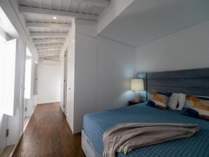 a bedroom with a blue bed and white walls at Casa da Portelinha in Arcos de Valdevez +22 photos