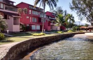 a river in front of a red building at Apartamento Angra dos Reis 2 novo in Angra dos Reis