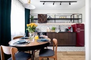 a kitchen with a table and chairs and a red refrigerator at Praia Apartments - 200 m do Plaży Apartament z balkonem i widokiem in Sopot