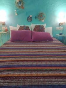 a bedroom with a large bed with purple pillows at Casa rural La Pradera in Villanueva de la Concepción