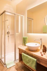 a bathroom with a sink and a shower at Hotel Hubertushof in Lermoos