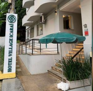 un parasol vert sur le côté du bâtiment dans l'établissement Hotel Village Icaraí, à Niterói