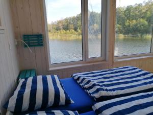 two beds in a boat with two windows at Dom na wodzie in Piecki