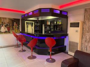 - un bar avec tabourets rouges dans une pièce dans l'établissement Denizhan Hotel, à Antalya
