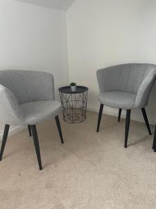 two chairs and a table in a room at Haymills Guesthouse in Solihull