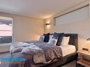 a bedroom with a bed with a large window at The Peak 5 in Thredbo