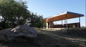 un edificio en la cima de una colina con una roca en Complejo Joansa, en Villa Santa Cruz del Lago
