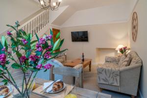 a living room with a table with purple flowers on it at Kent Cottage - Town centre, with parking in Kendal