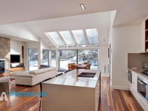 une cuisine et un salon avec une grande fenêtre dans l'établissement The Peak Penthouse 8, à Thredbo