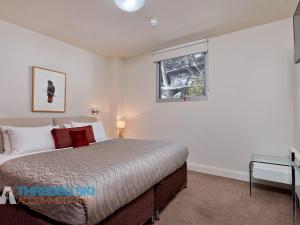 une chambre avec un lit et une fenêtre dans l'établissement The Peak Penthouse 8, à Thredbo