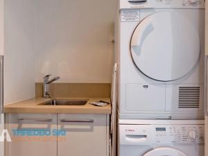 une petite cuisine avec un évier et un micro-ondes dans l'établissement The Peak Penthouse 8, à Thredbo 7 autres photos