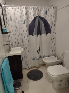 - Baño con cortina de ducha y sombrilla en Apartamento Costa del Sol en Mar del Plata
