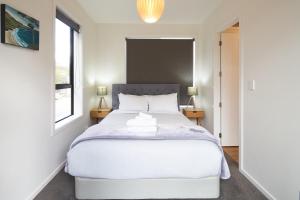 a bedroom with a large white bed and two lamps at Lily Cottage - Lake Tekapo in Lake Tekapo