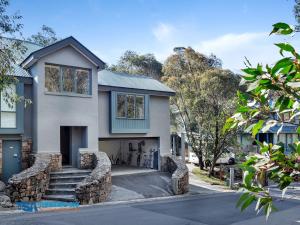 a house with a stone retaining wall at Wintergreen 5 in Thredbo