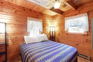 ein Schlafzimmer mit einem Bett in einer Holzhütte in der Unterkunft Easton Escape a notch above in Sugar Hill
