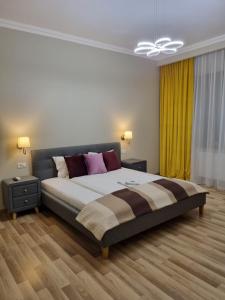 a bedroom with a large bed and a ceiling fan at City Inn Premium Apartment in Timişoara