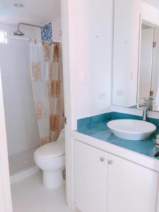 La salle de bains blanche est pourvue d'un lavabo et de toilettes. dans l'établissement Sitio exclusivo y tranquilo, à San Andrés
