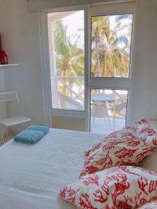 a bedroom with a bed with a view of a palm tree at Sitio exclusivo y tranquilo in San Andrés