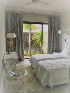a bedroom with a bed and a table and a glass chair at Luxury Villa at Royal Park Sandpiper in La Bergerie