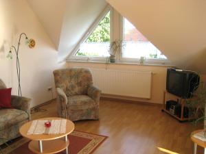 ein Wohnzimmer mit 2 Stühlen und einem TV in der Unterkunft Ferienwohnung Dimter in Ostseebad Koserow